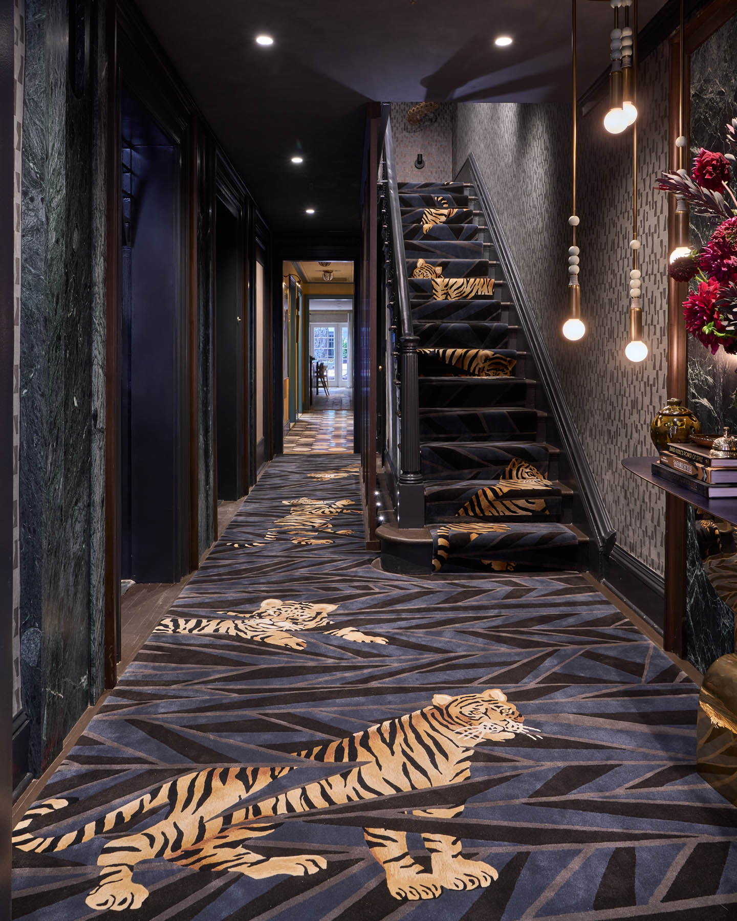 foyer and staircase with moody blue-black fabrics and wallcoverings featuring a tiger motif 