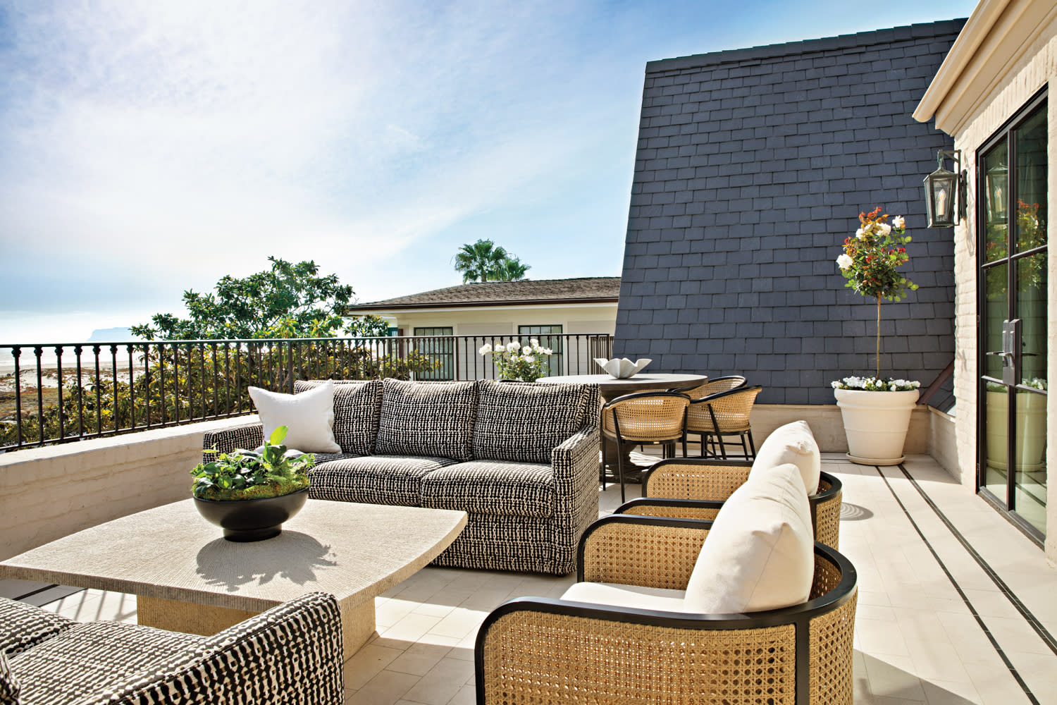 outdoor terrace with patterned sofas, rattan armchairs and ocean views