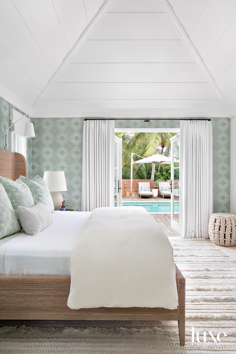 bedroom with green wallcovering, natural rug and white accents