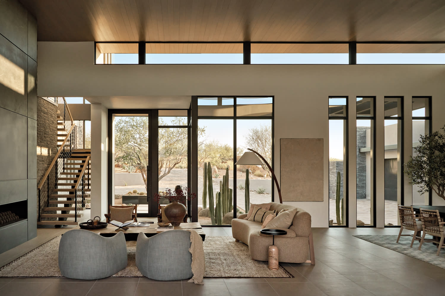 contemporary neutral great room with a large fireplace and desert views outside