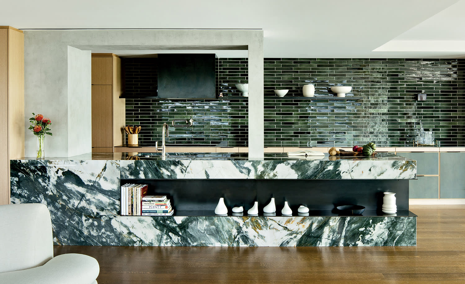 open concept kitchen with black subway tile and a marble island