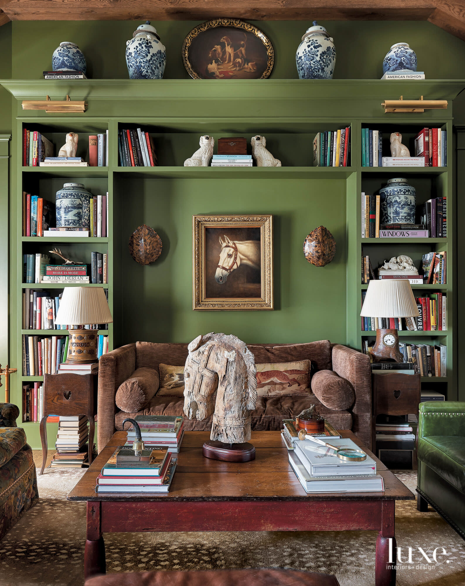 Room with green walls, bookshelves, art