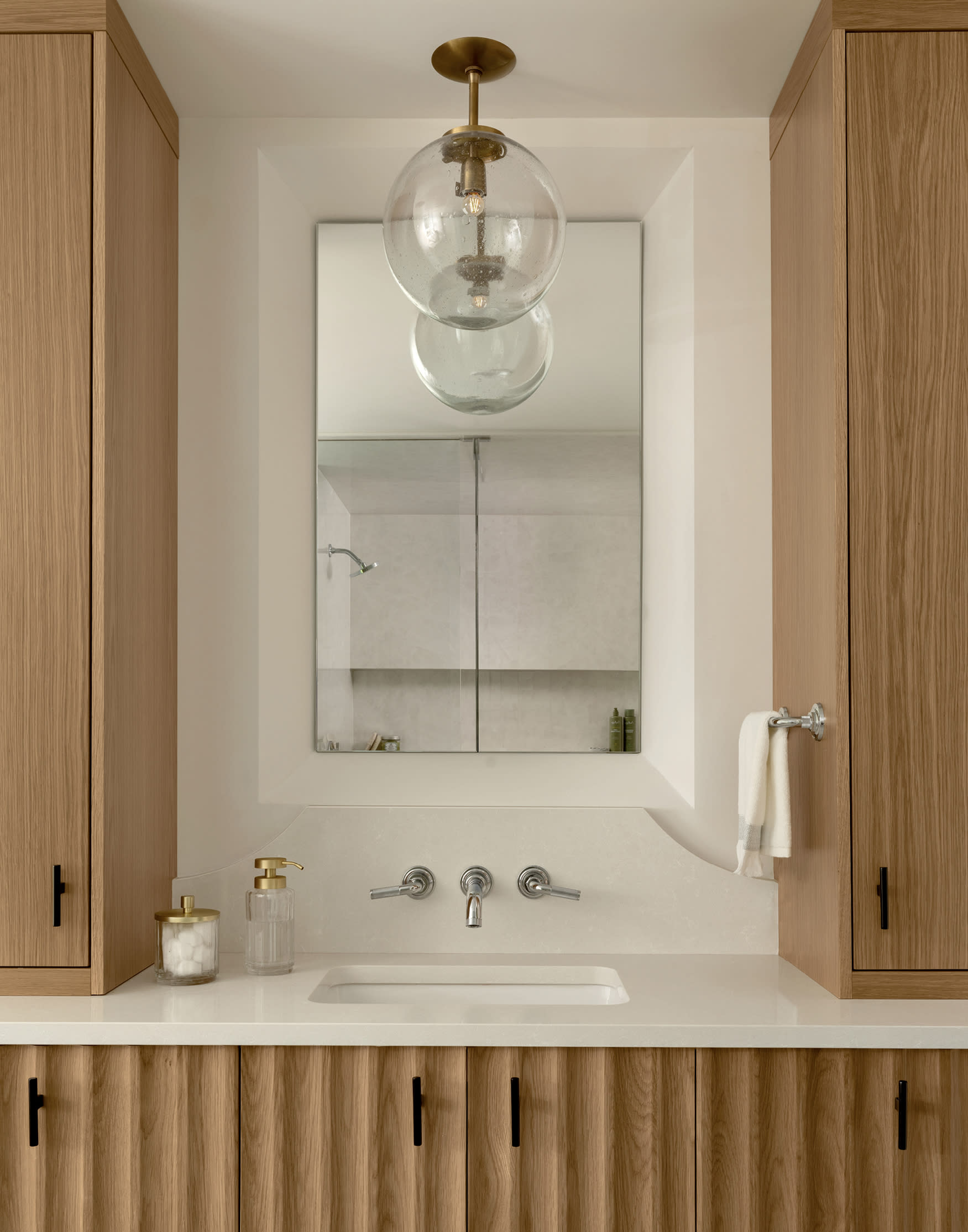white oak vanity with fluted detailing in a classic bathroom