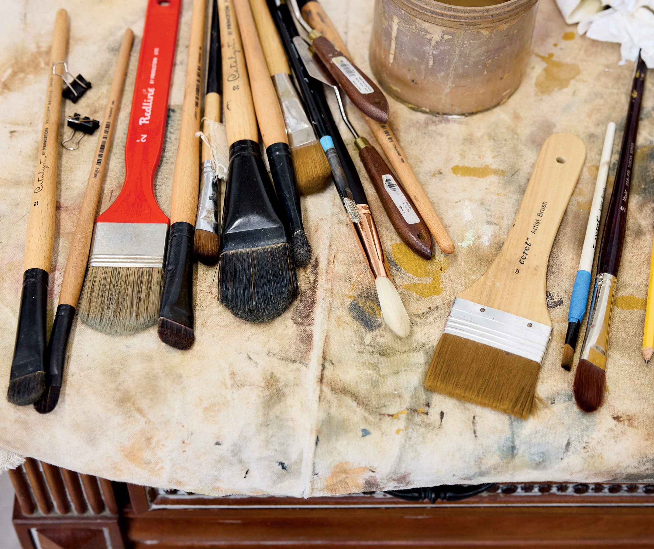 collection of paint brushes on a tablecloth