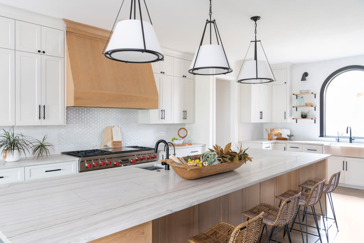 white kitchen with taj mahal quartzite and rattan-wrapped barstools