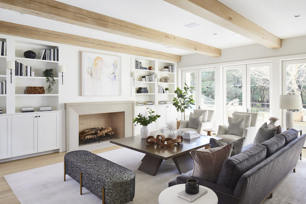 Exposed beams and built-in shelving add character and charm to this open living room. 