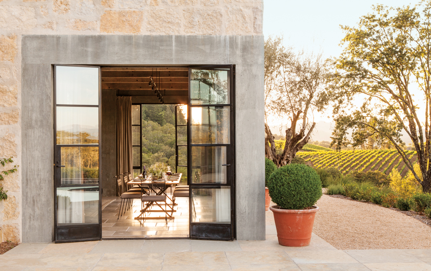 French doors opening up to a dining room overlooking a vineyard.