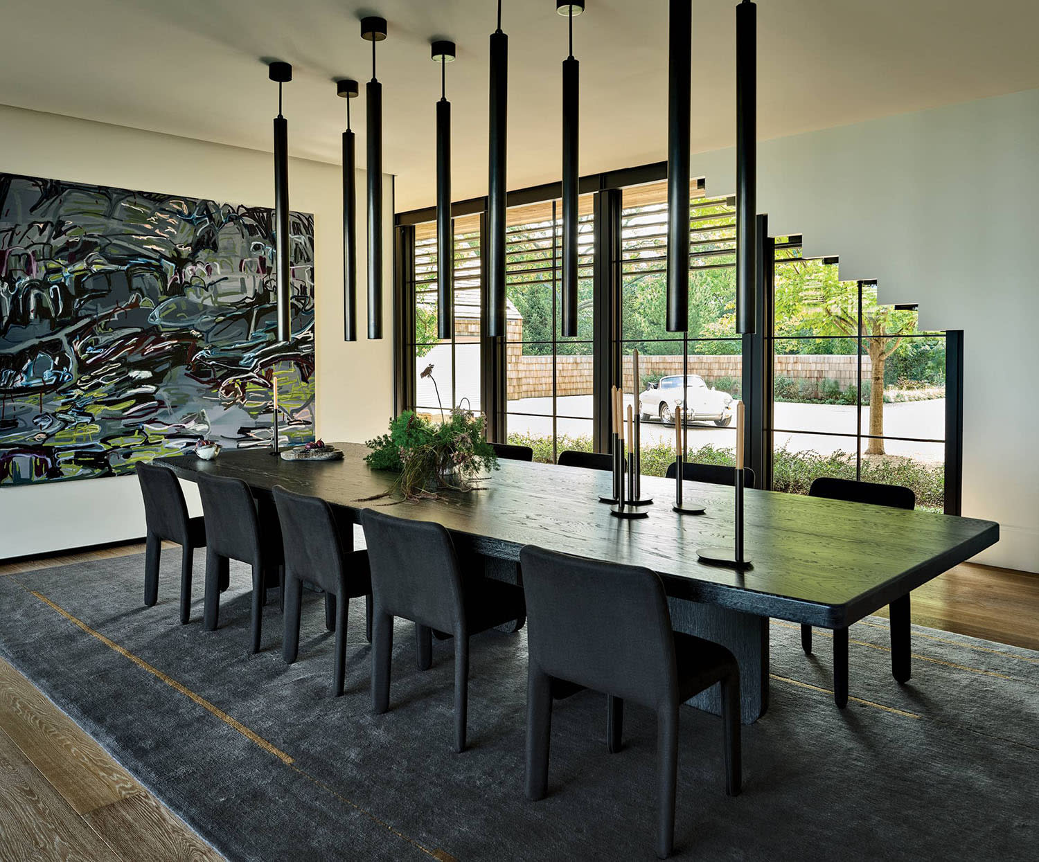 moody black and white dining room with Apparatus pendants over the table