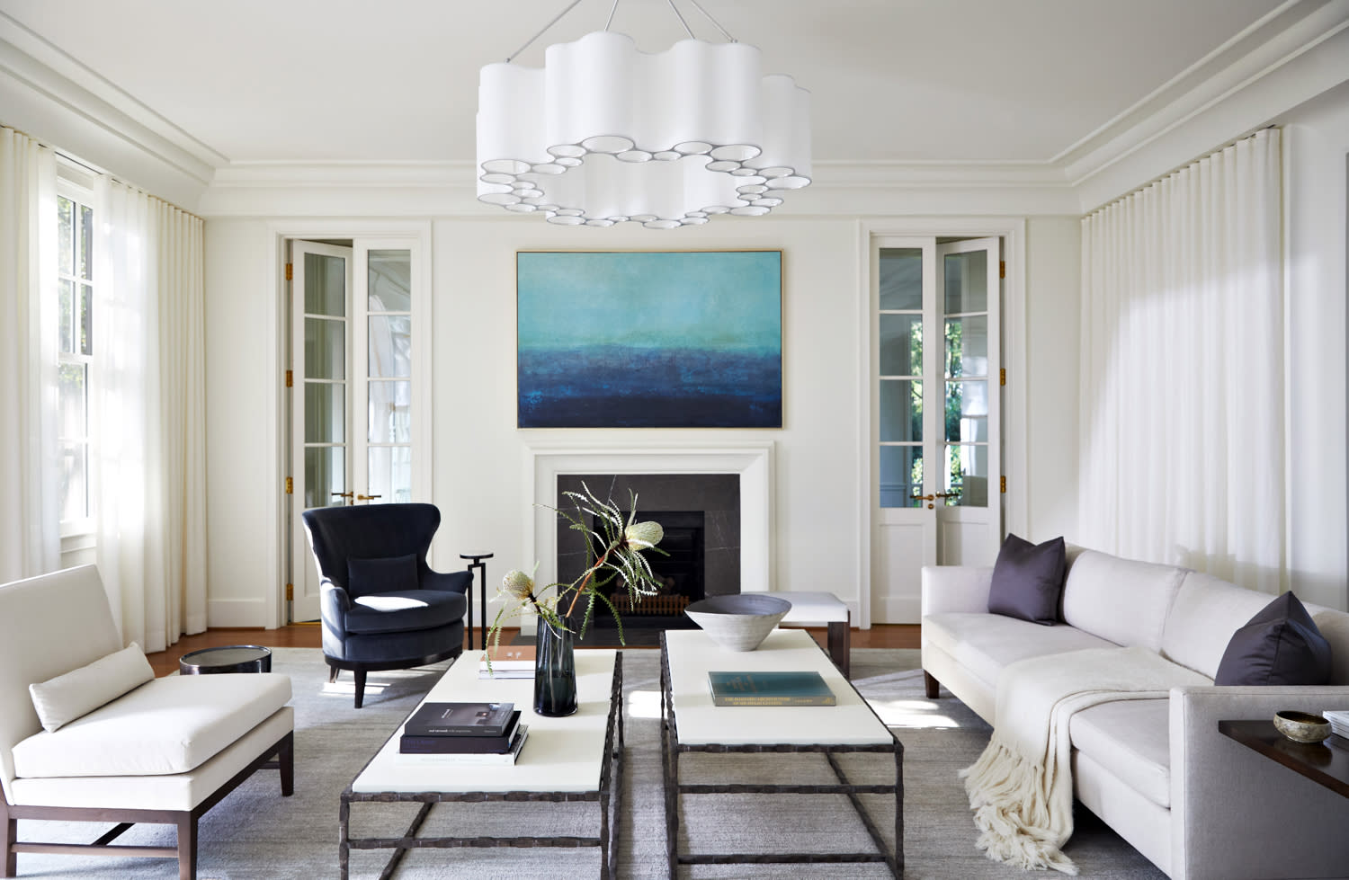 contemporary white living room with a blue artwork over the fireplace