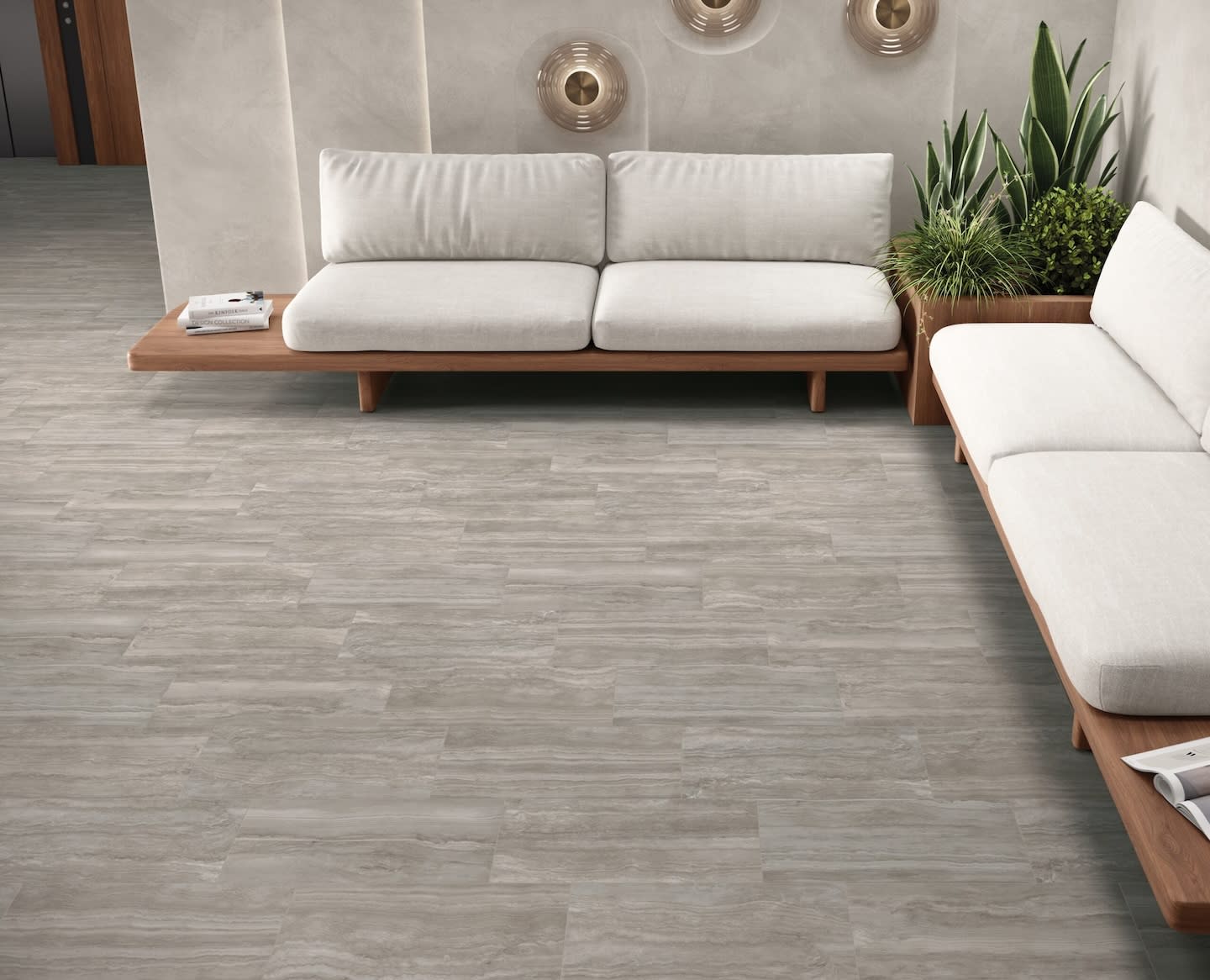 Modern living room with light gray, wood-like tile flooring. Minimalist white sofas and green plants create a calm, contemporary atmosphere.