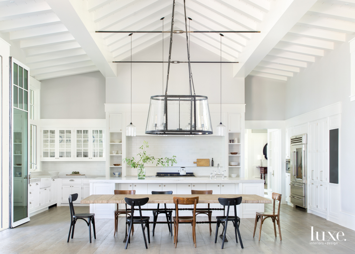 transitional dining area in kitchen white cabinetry brown and black chairs