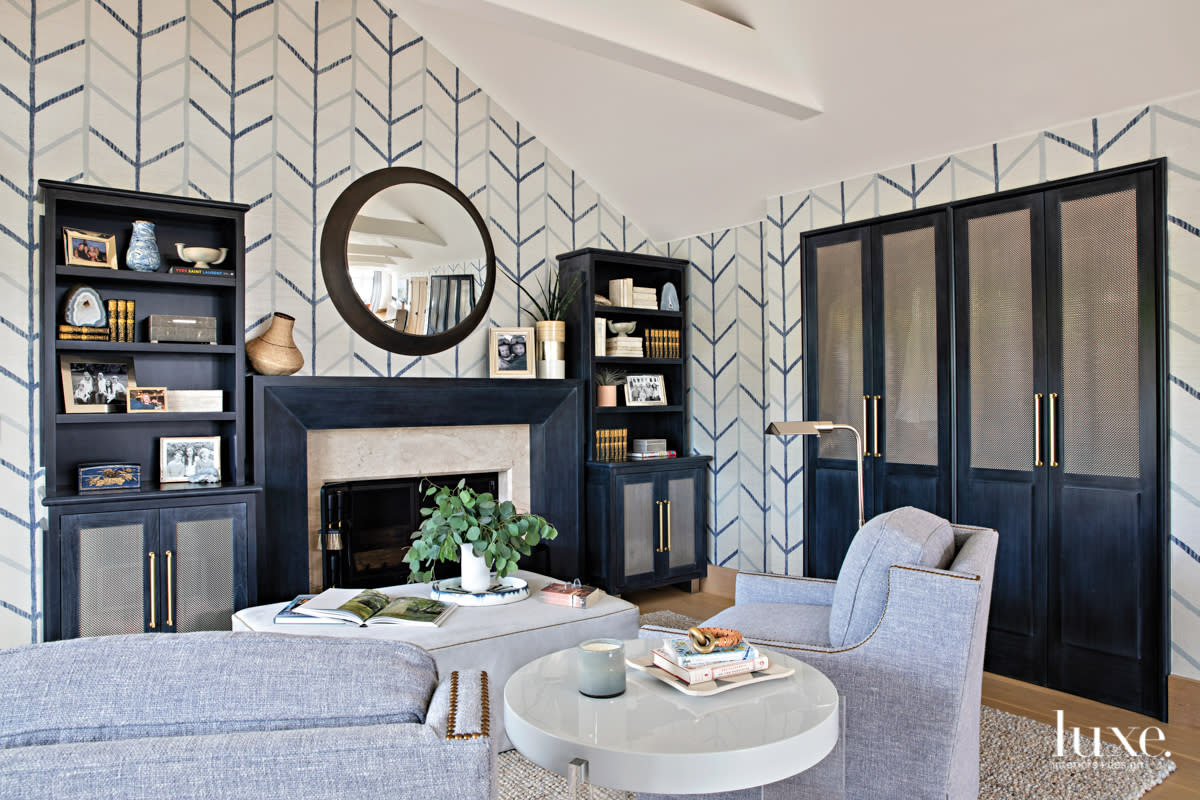 Master bedroom sitting area with fireplace and a blue patterned wall