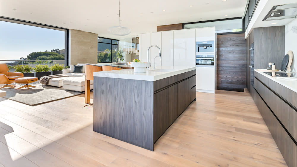 A contemporary kitchen featuring a spacious island and elegant European oak flooring, showcasing modern design elements.