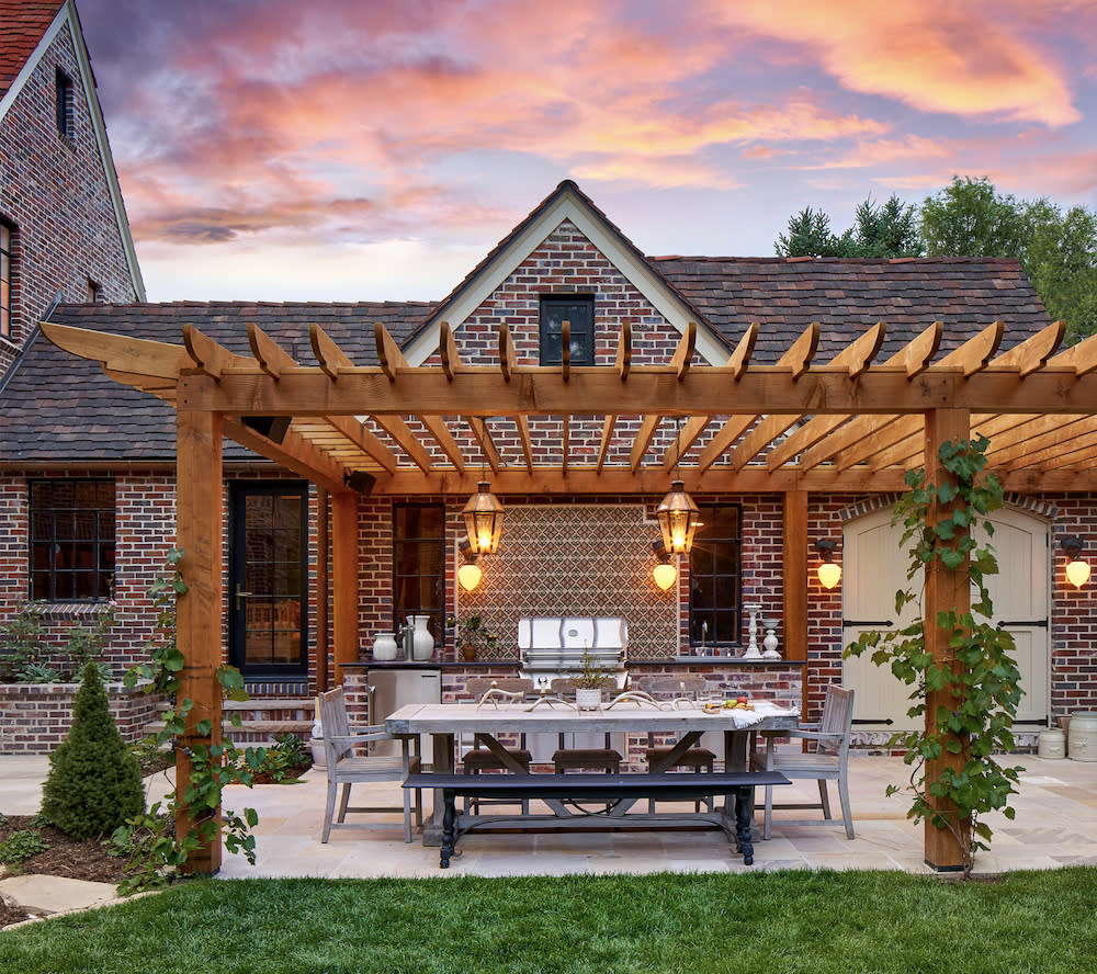 A patio with a pergola and a table, providing a cozy outdoor space for relaxation and dining.