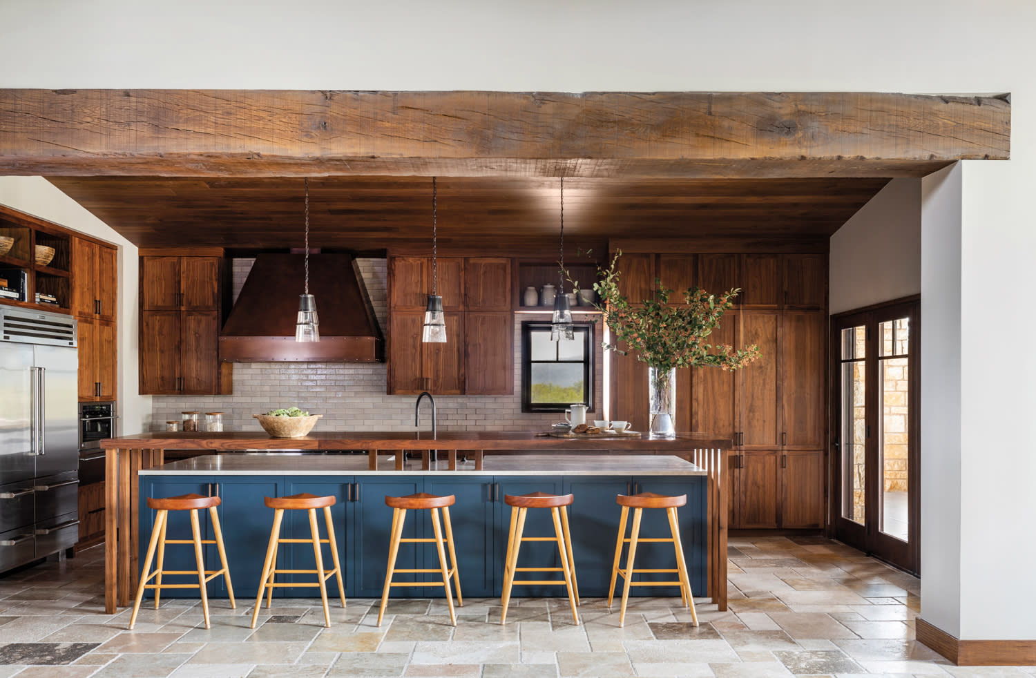 kitchen with wood cabinetry and large blue island with kitchen stool sin home by Blair Burton