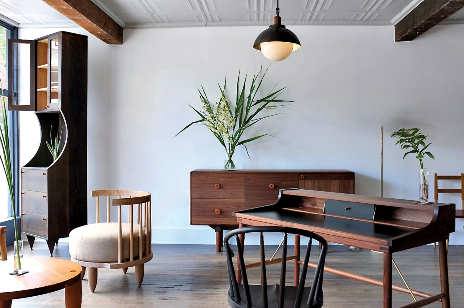 armchairs in front of a credenza with a plant on it