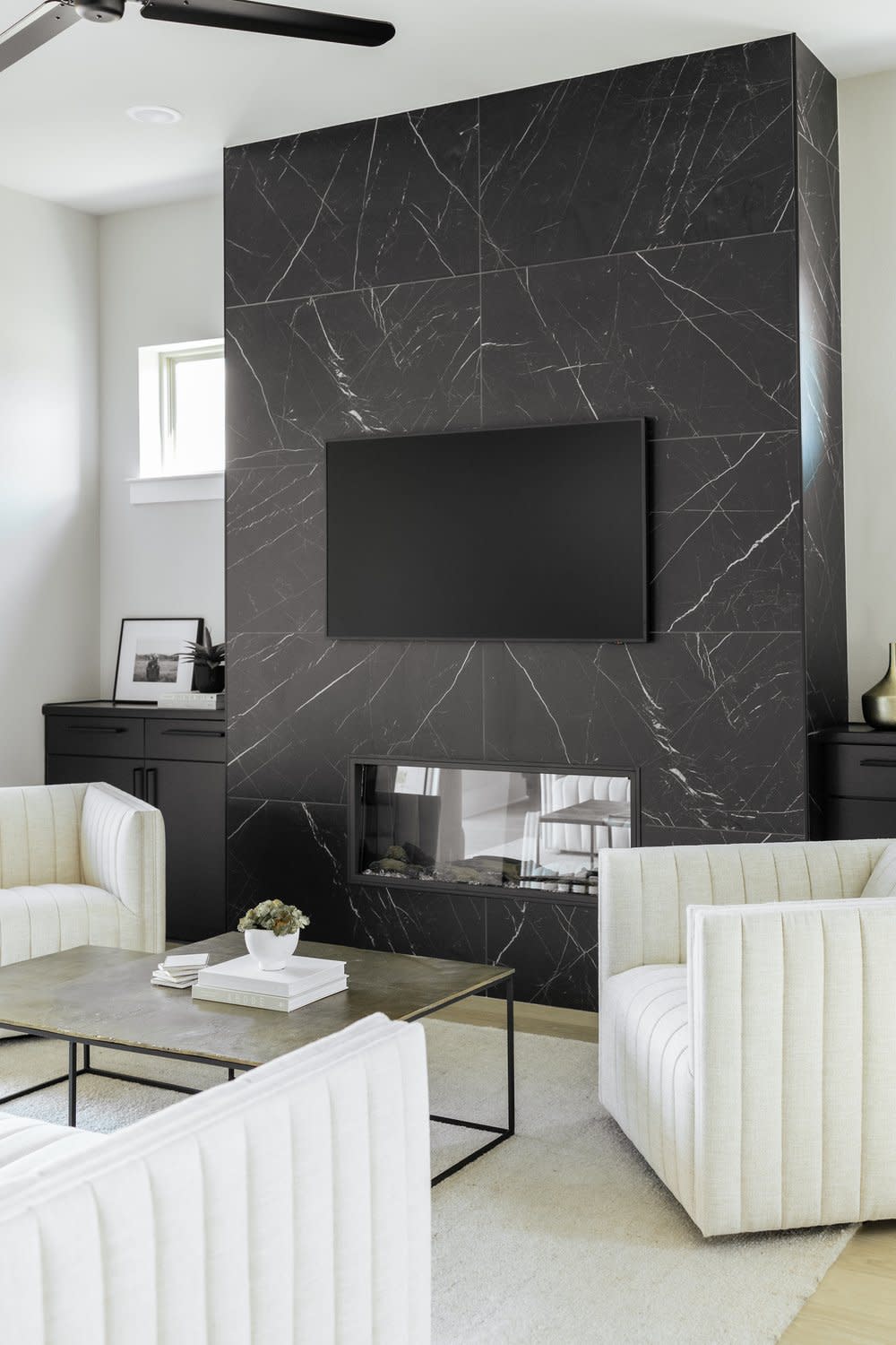 Stylish living room featuring black marble walls and chic white furnishings