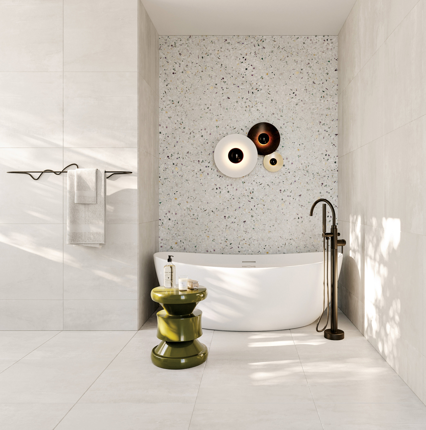 Freestanding white tub in bathroom niche with a sculpture light fixture and a green side table