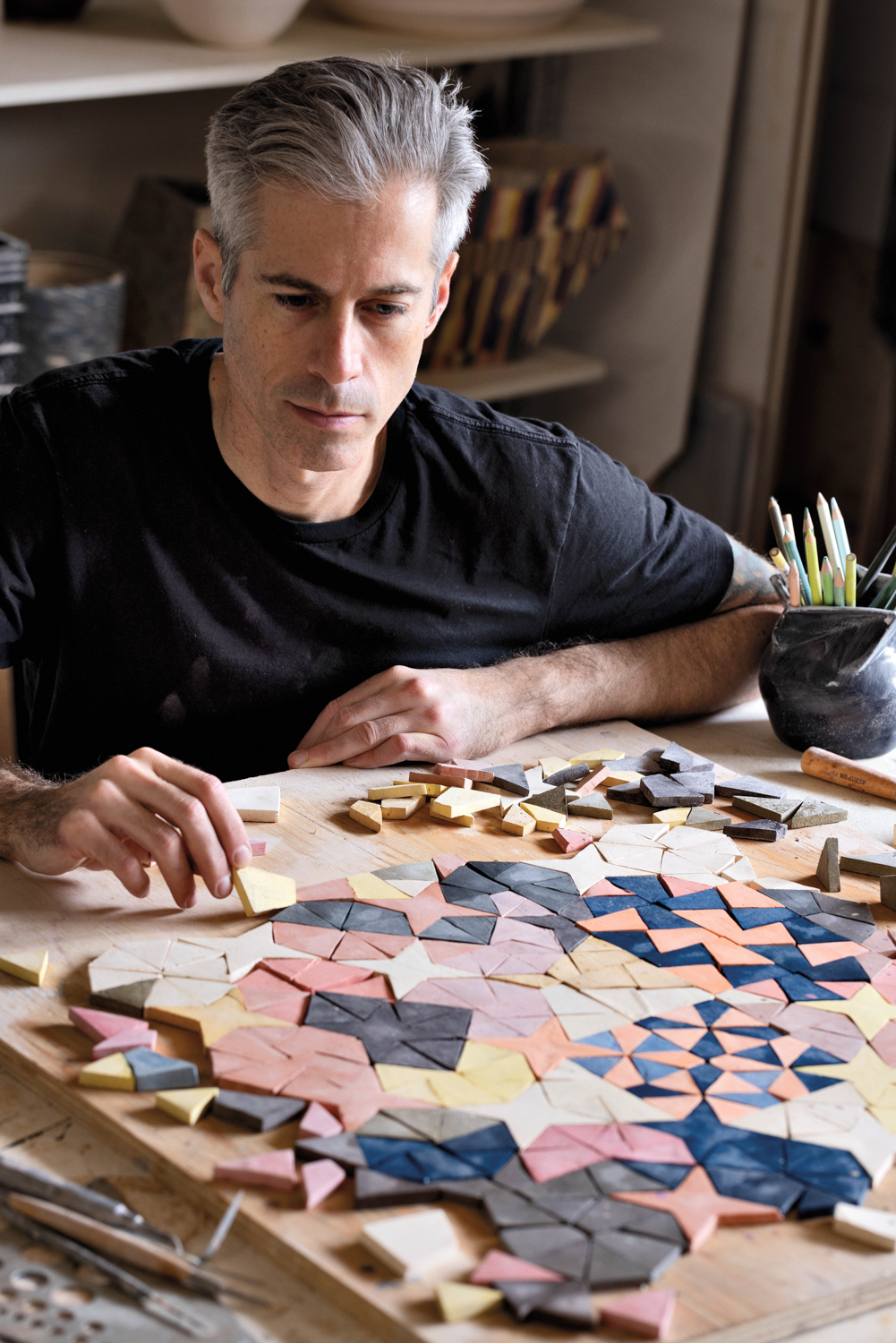 Artist Cody Hoyt in front of colorful origami