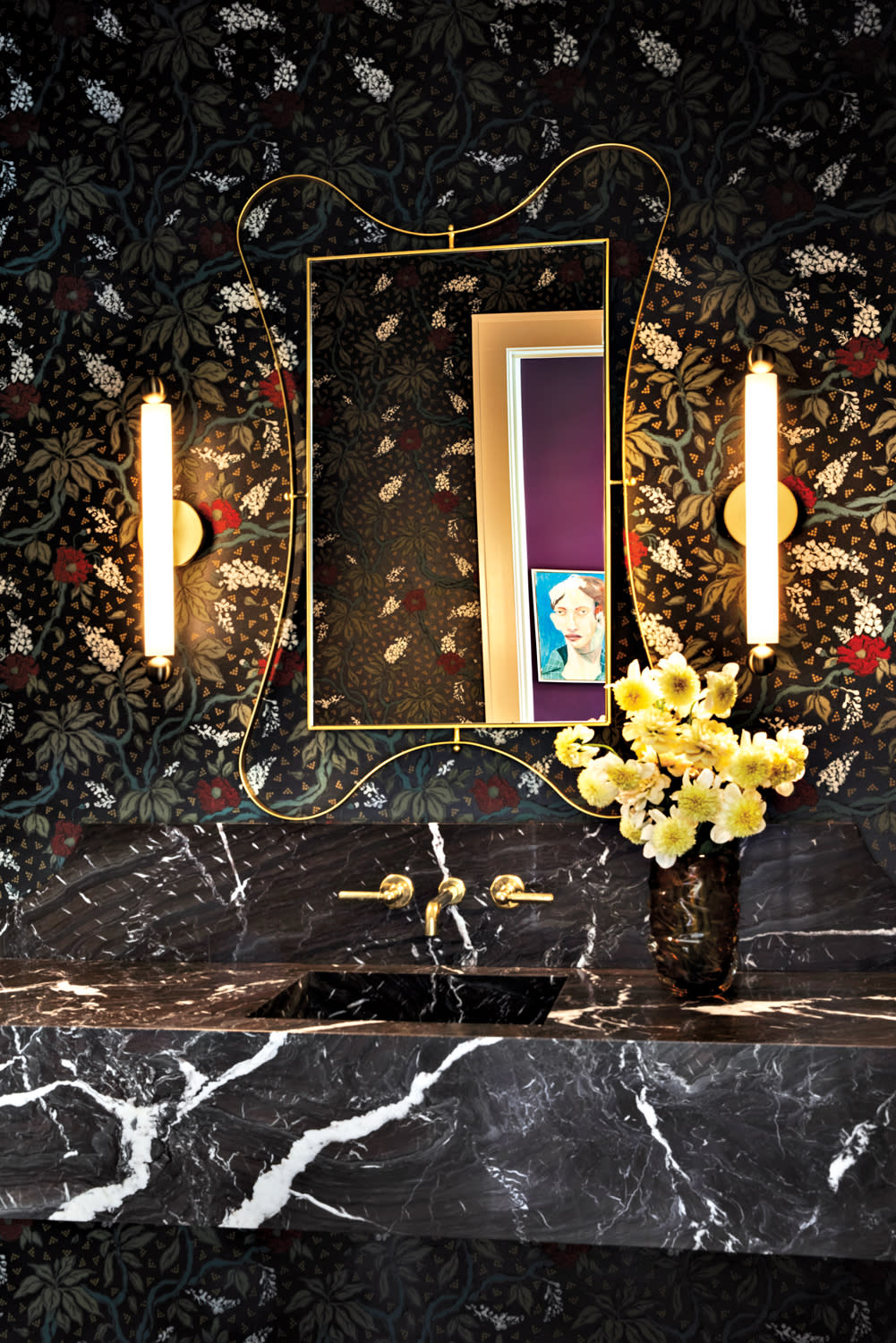 moody powder room with black marble countertops and floral wallpaper