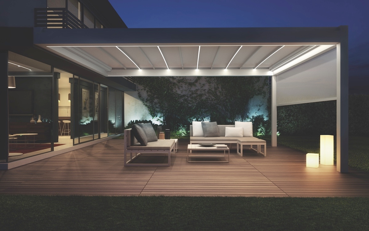 A patio featuring a white roof and outdoor furniture, creating a cozy and inviting outdoor space.