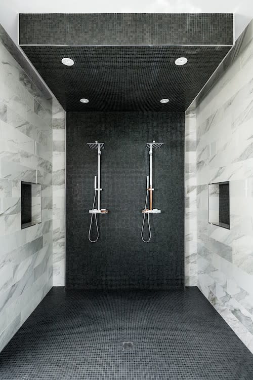 Monochrome spacious shower featuring black and white tiling.