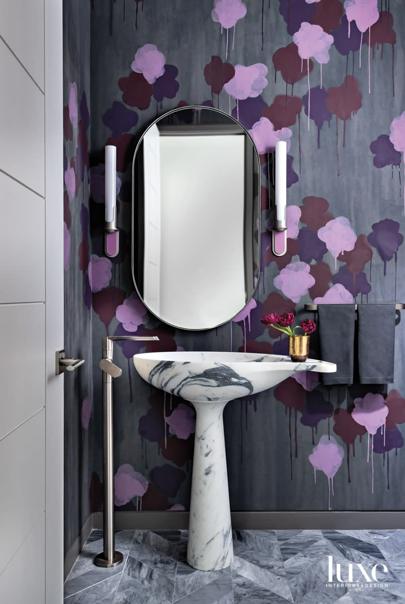 Powder bathroom with statement wallpaper and a pedestal sink.