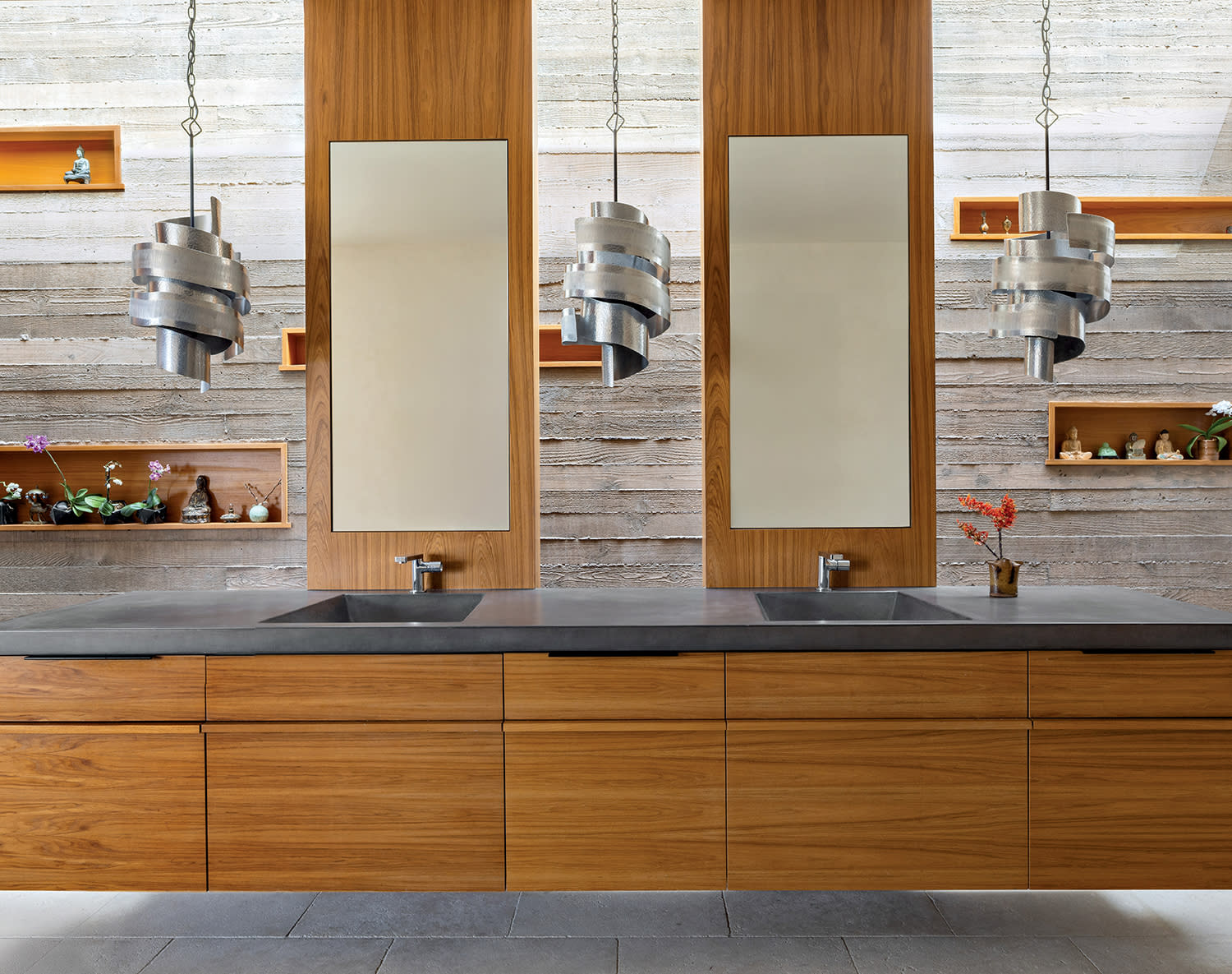 modern primary bath with a floating teak vanity and mirrors
