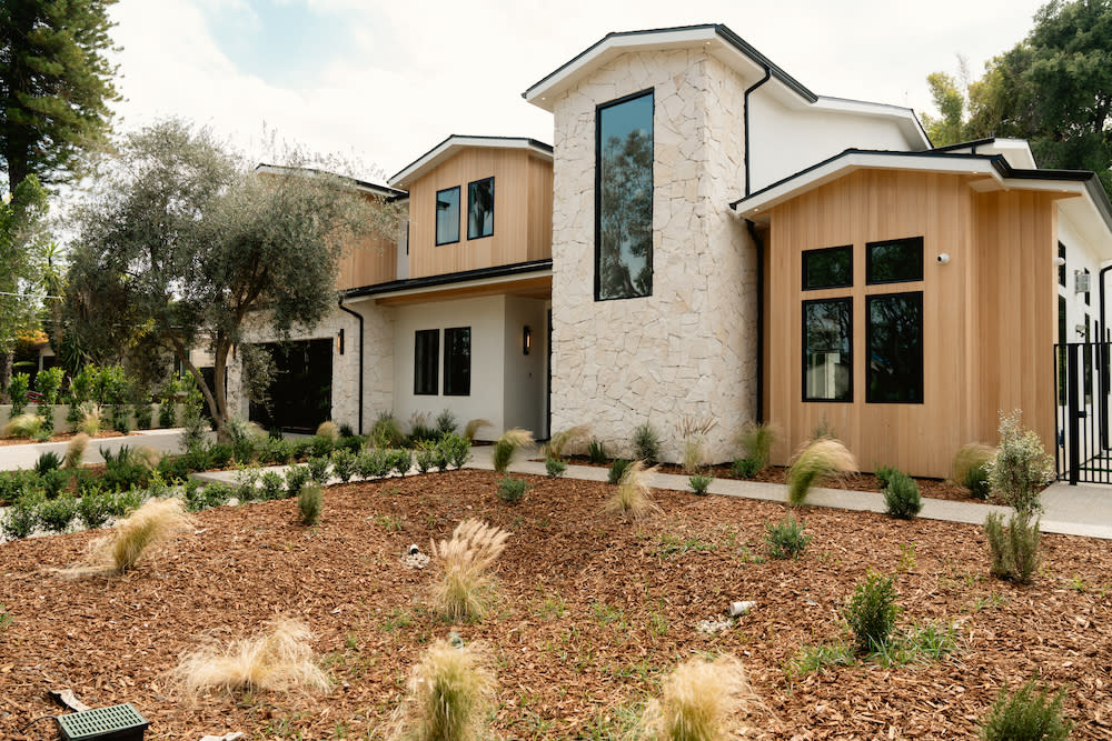 A lovely house nestled in a landscaped garden, complete with a variety of trees enhancing the serene environment.