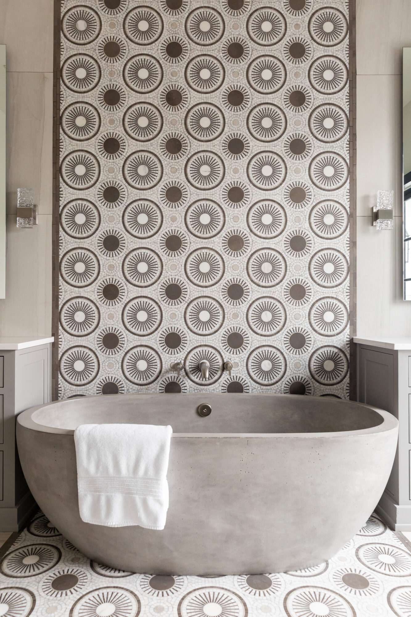 free standing gray stone tub with tile backsplash 