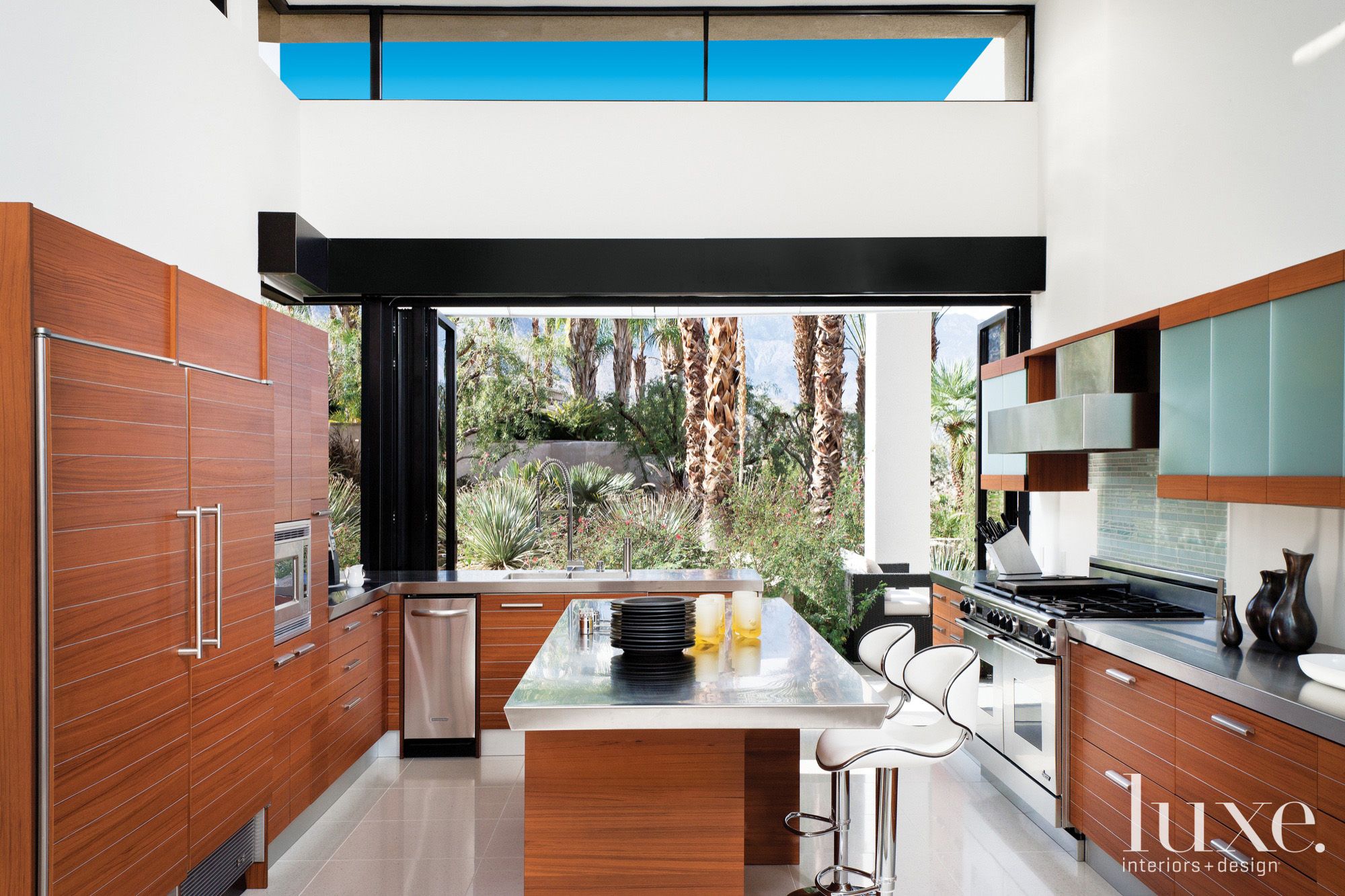 brown cabinetry in a spacious light-filled white kitchen