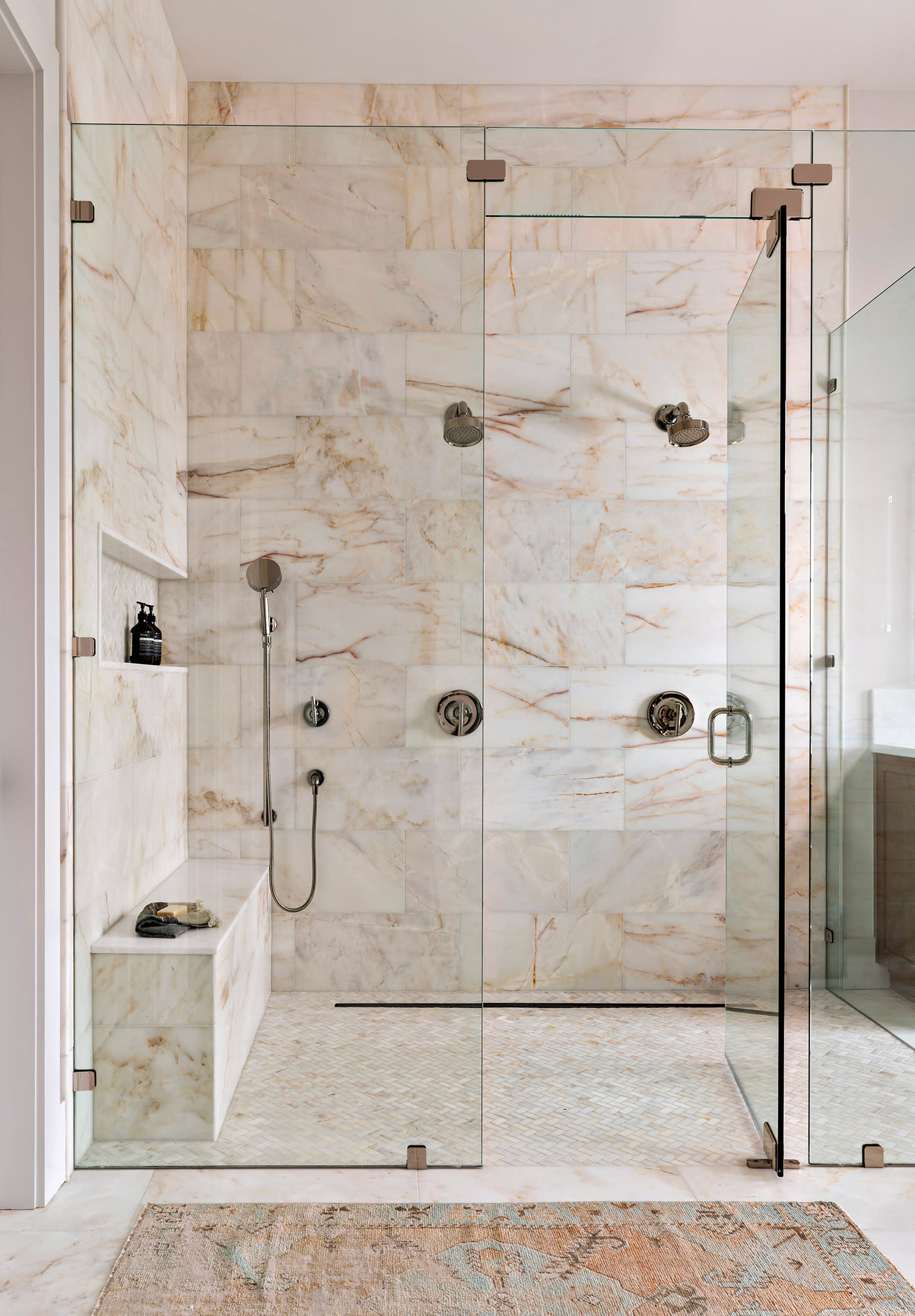 bathroom featuring a shower surrounded by Calacatta Amber marble walls
