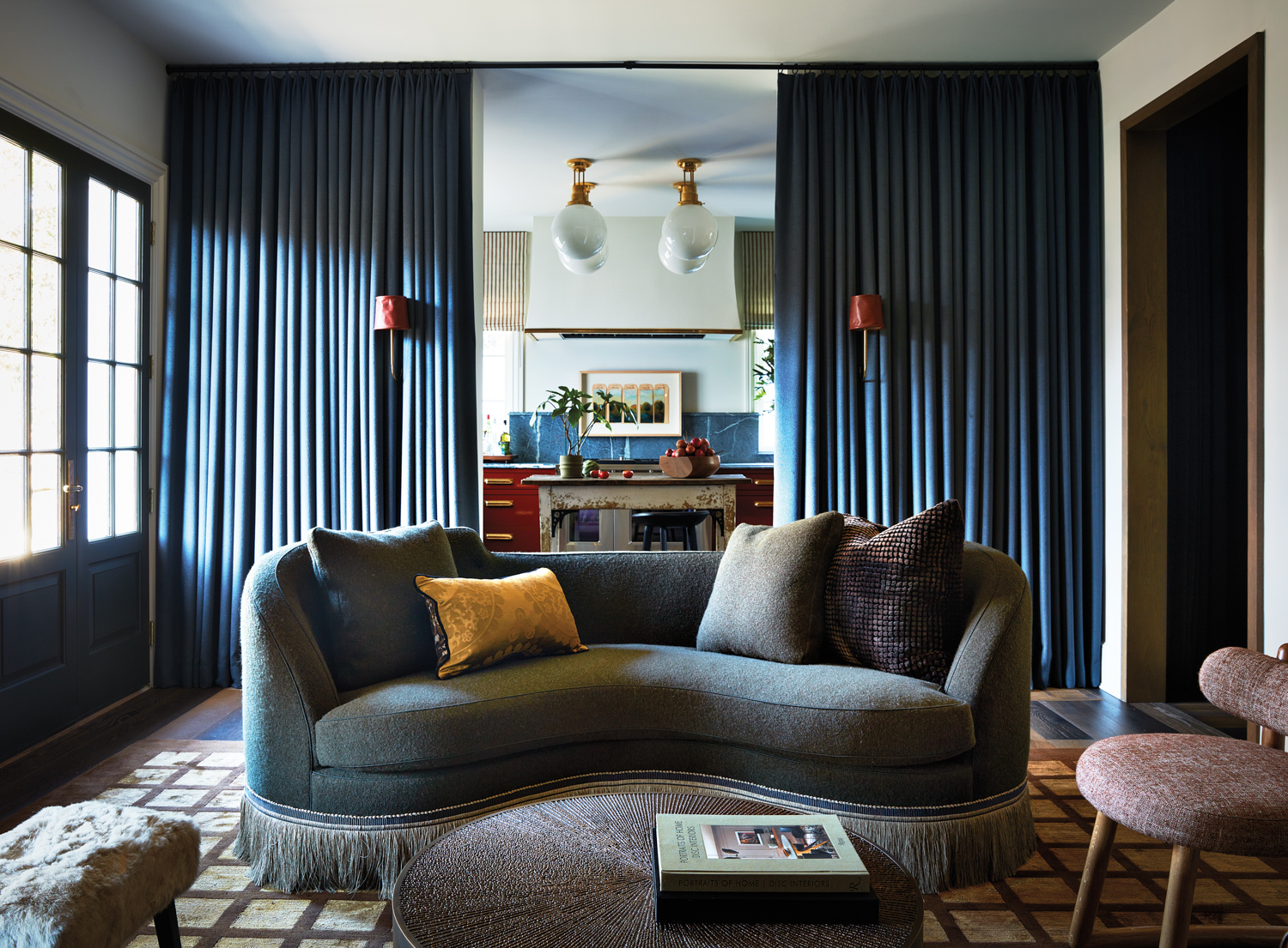 Lounge-like living area with a kidney-shaped sofa, drapery walls and window pane-patterned rug