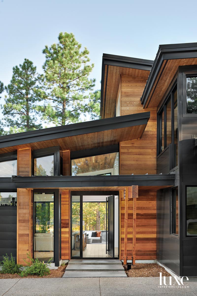 The exterior of a modern, angular wood-and-steel house.