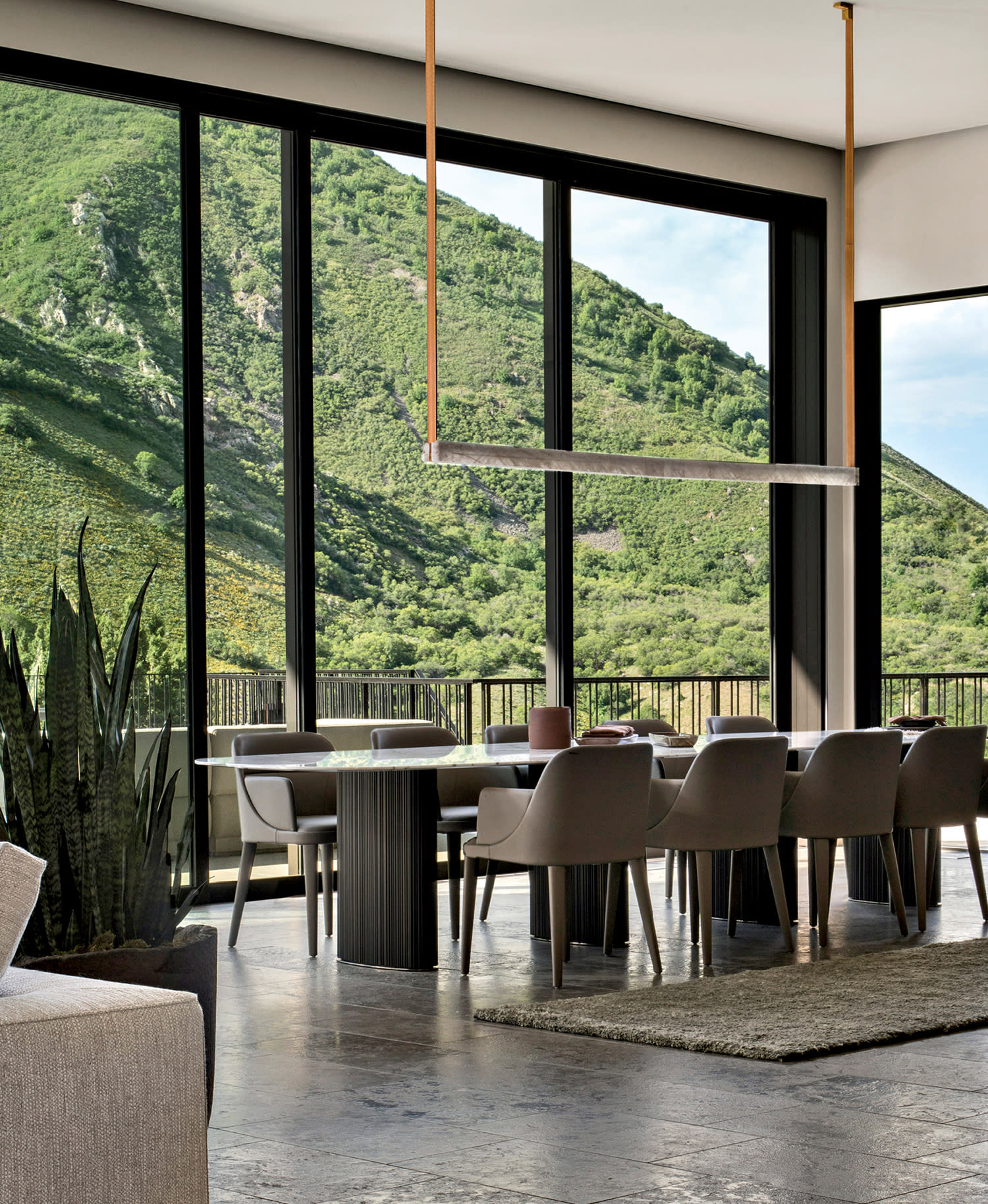 modern dining area in a mountain home with ridgeline views outside the floor-to-ceiling windows