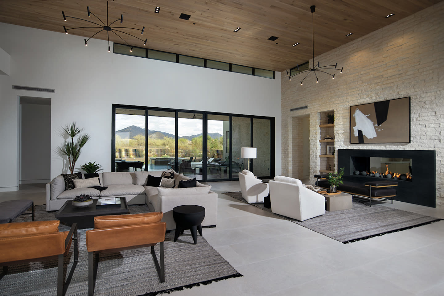 Modern living room with neutral sofa, fireplace, desert view