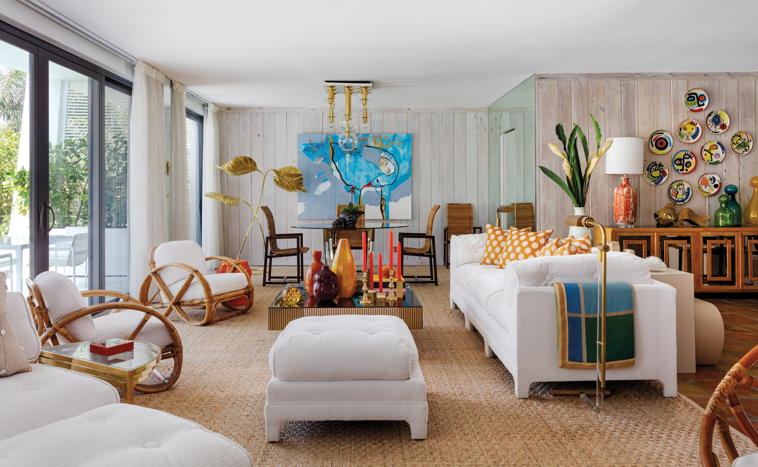 living area with rattan pretzel chairs, upholstered white furnishings, large sisal rug, dining area and blue artwork