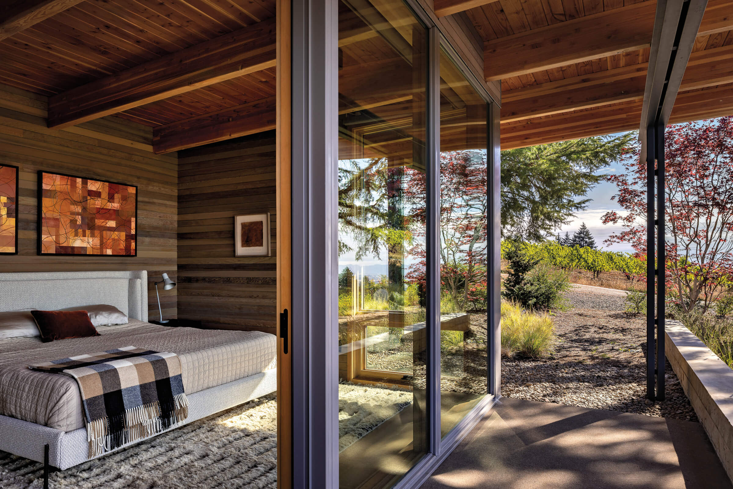 cozy bedroom with wood walls and floor to ceiling windows