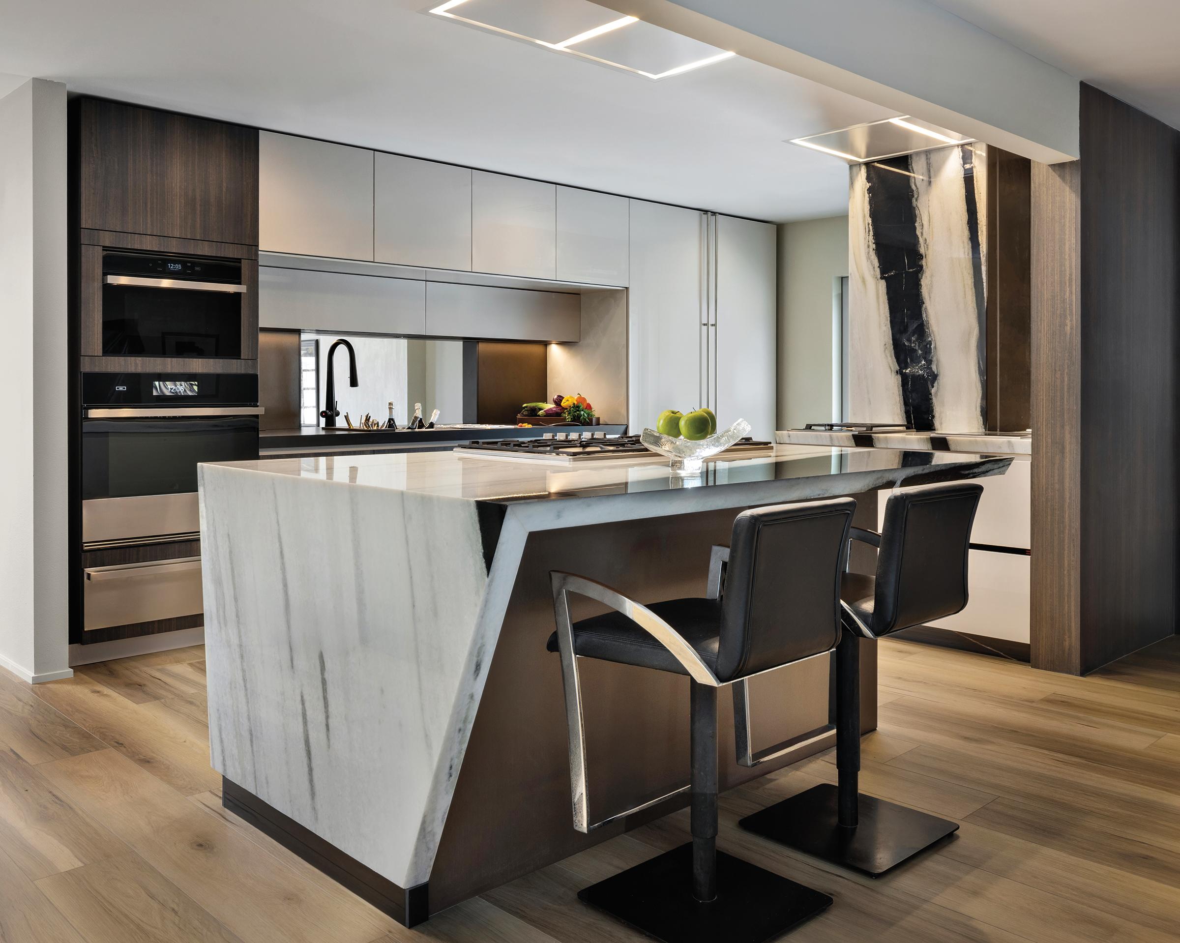 Open-concept view of the Pazzam Project kitchen and living area, demonstrating cohesive materiality, concealed storage, and architectural continuity.