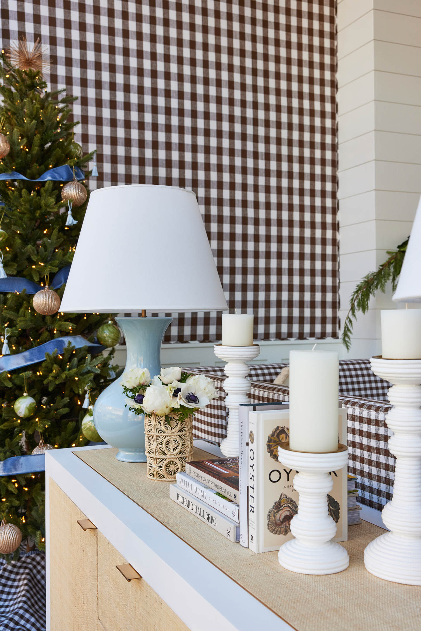 brown and white gingham lines the wall behind a Christmas tree