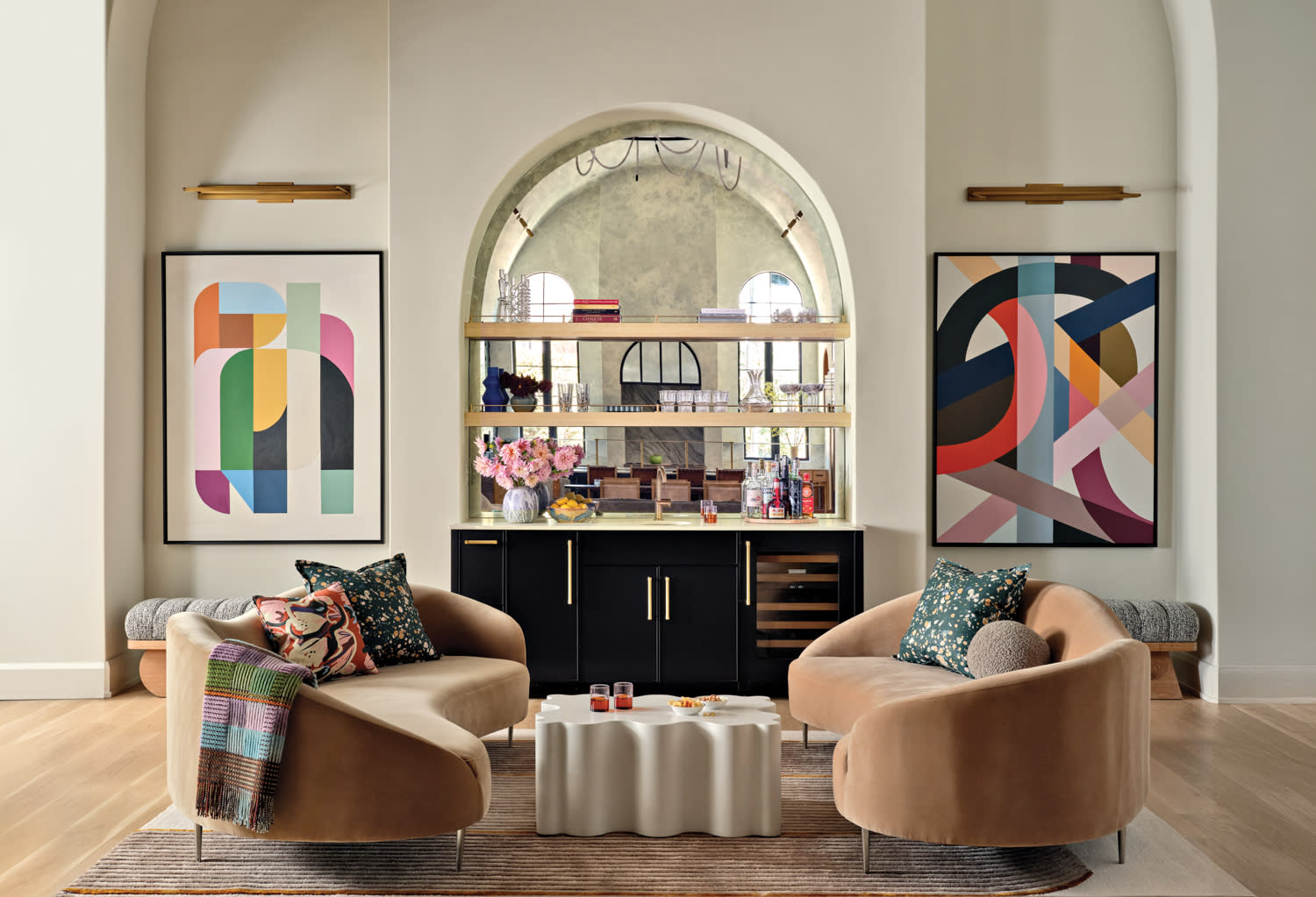 great room with a mirrored bar set into one wall flanked by two colorful artworks