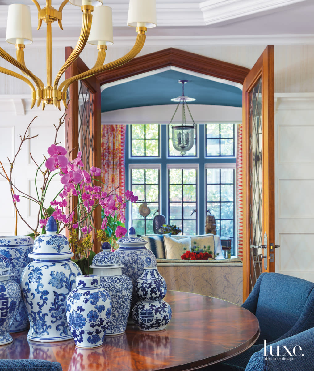 The dining room has a collection of blue-and-white ginger jars in the center of the table.