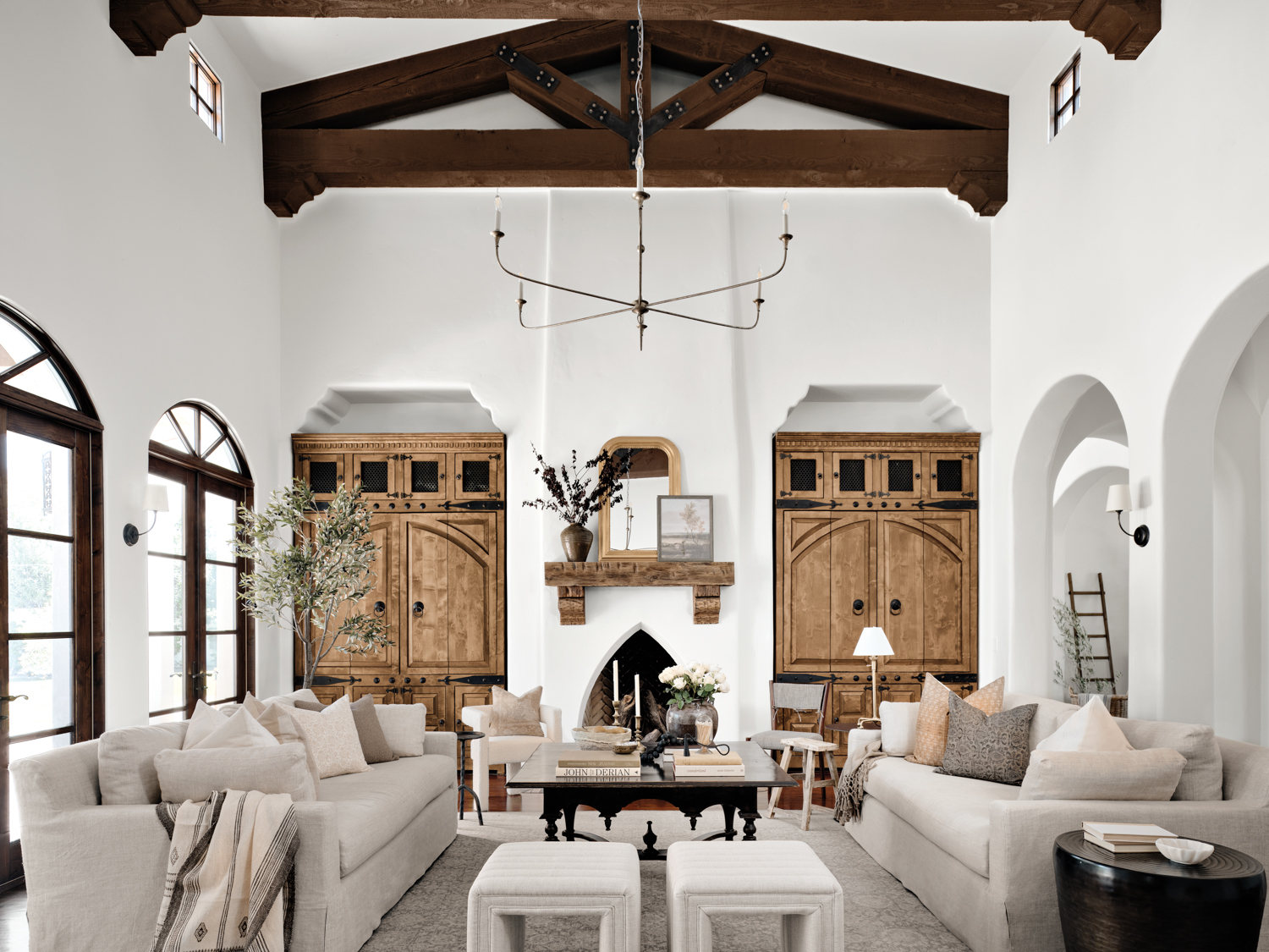 living room with wood ceiling beams, oak built-in cabinets and twin cream facing sofas