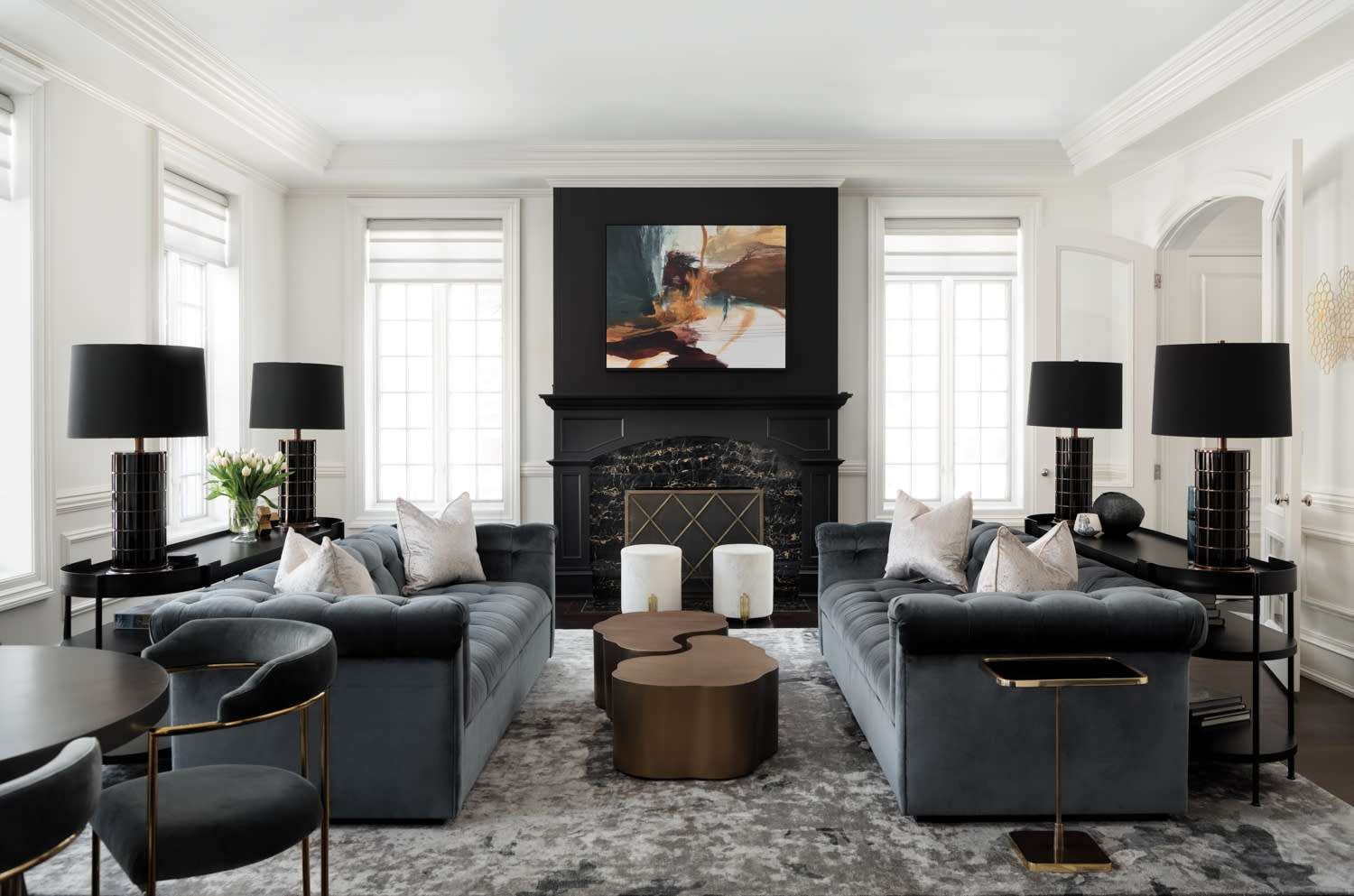 A gray, black and white living room with two gray velvet sectionals.