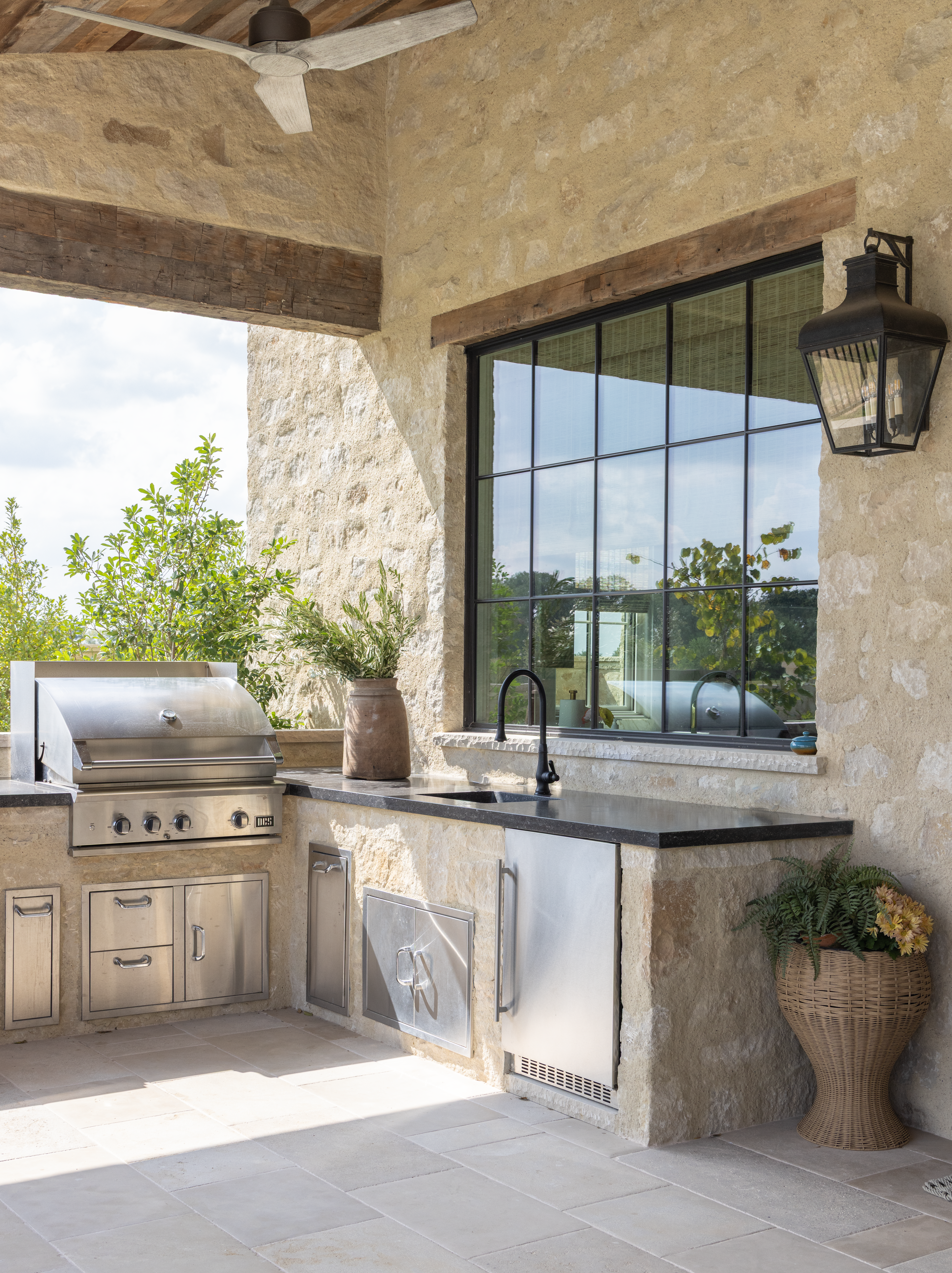 In Texas, outdoor living is essential — limestone floors and Belgian blue countertops create a seamless flow from indoors to out, bringing the same sense of comfort, durability, and understated elegance to every gathering. 