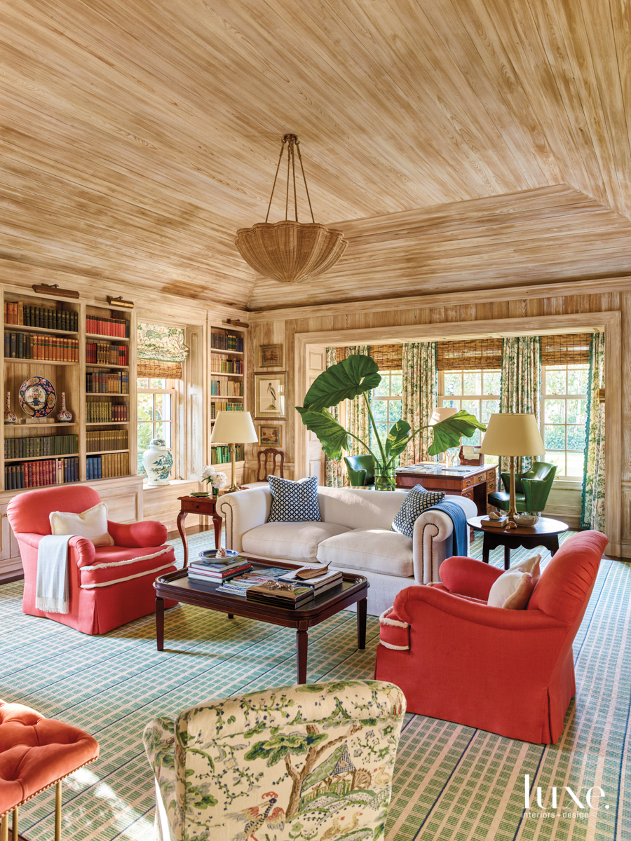 library with wood walls and ceiling and tangerine armchairs