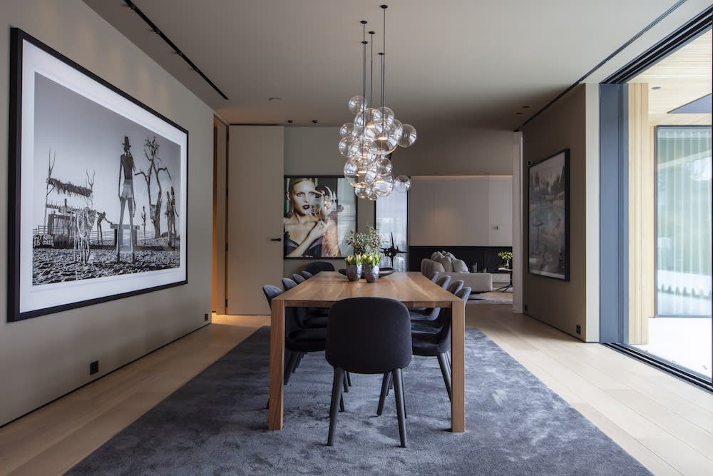 A spacious dining room featuring European oak floors and a large picture prominently displayed above the dining table, enhancing the decor.