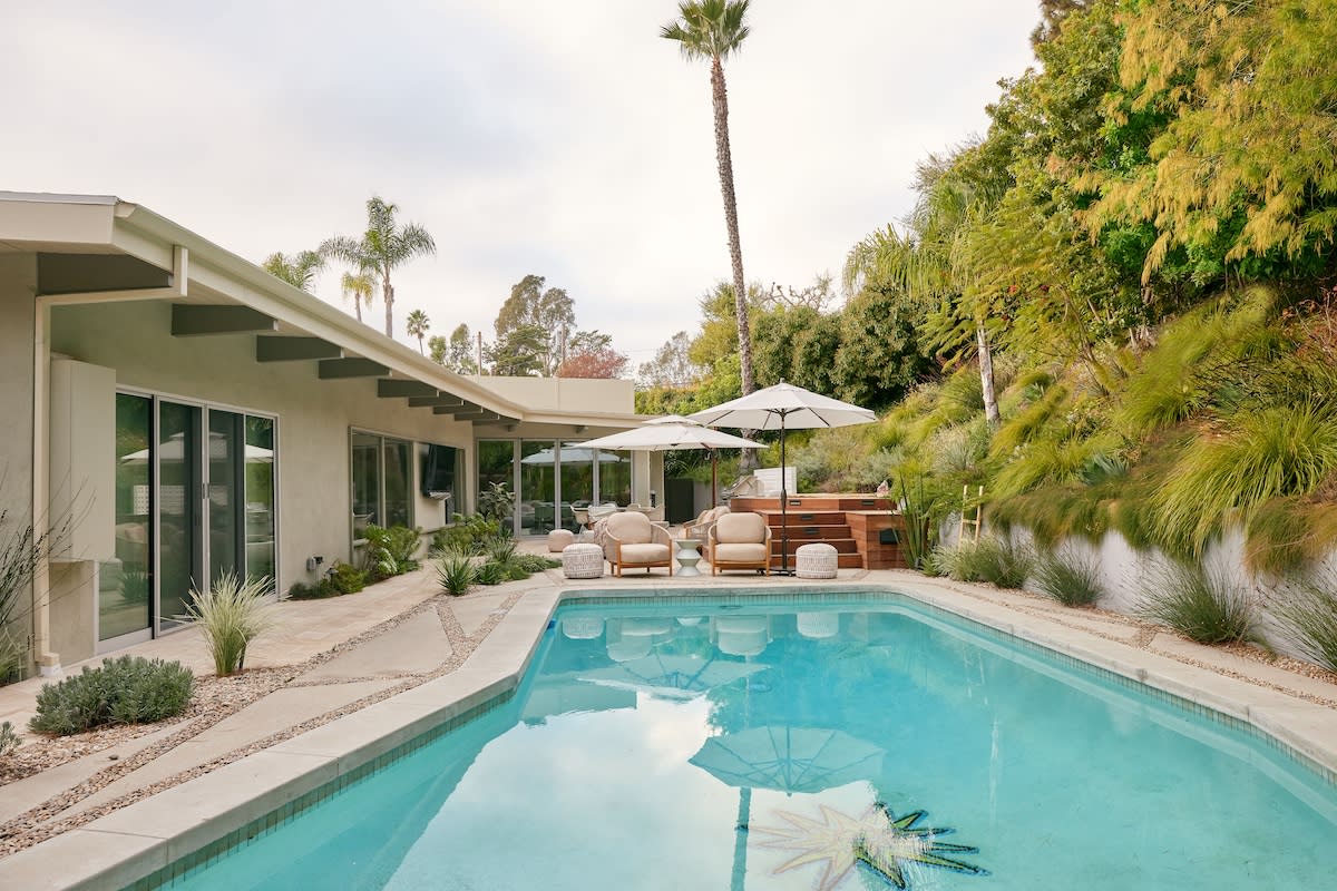 A backyard pool surrounded by a patio and lounge chairs, inviting relaxation and outdoor enjoyment.