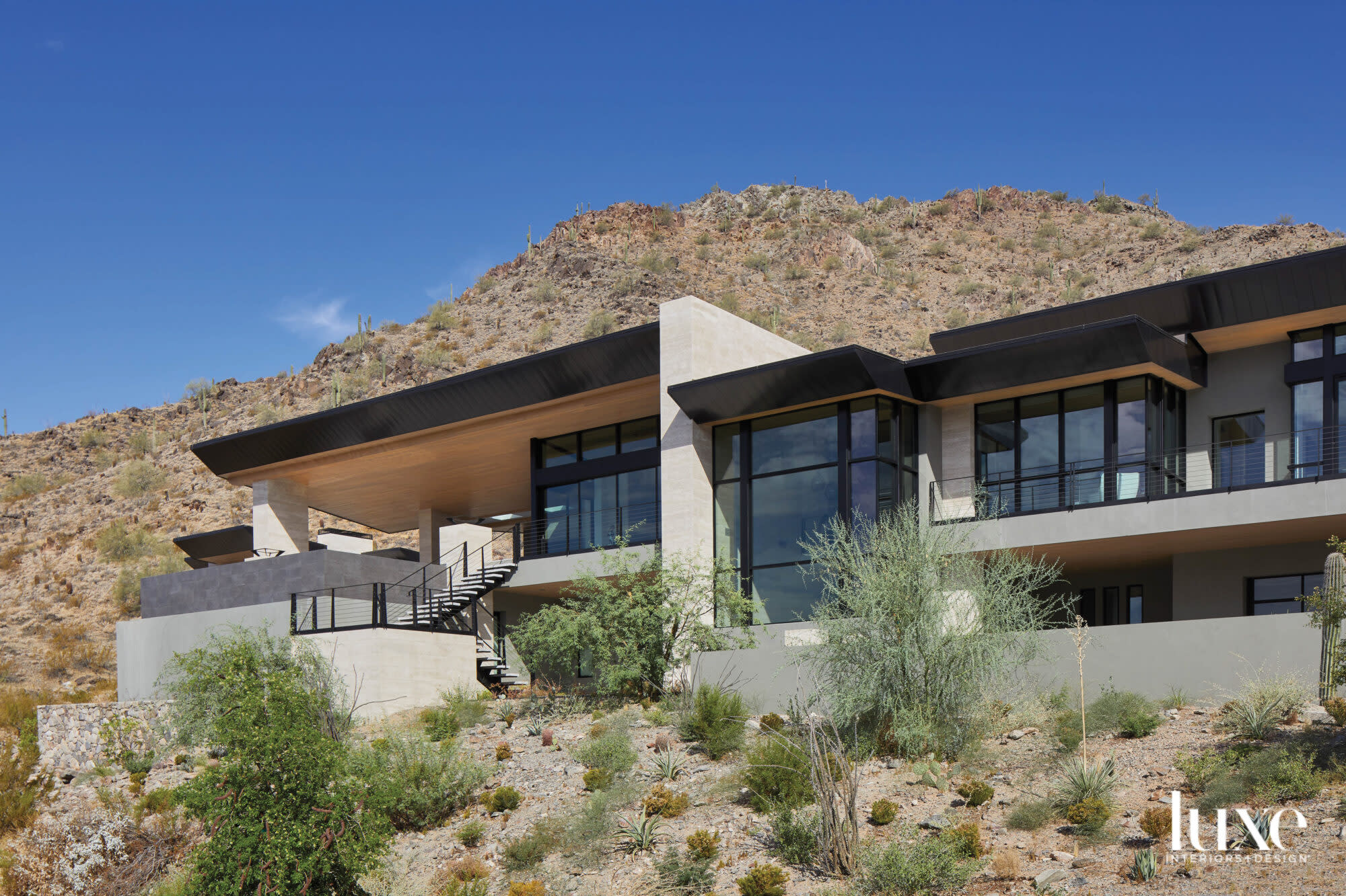 A modernist home with steel windows set against a mountain.