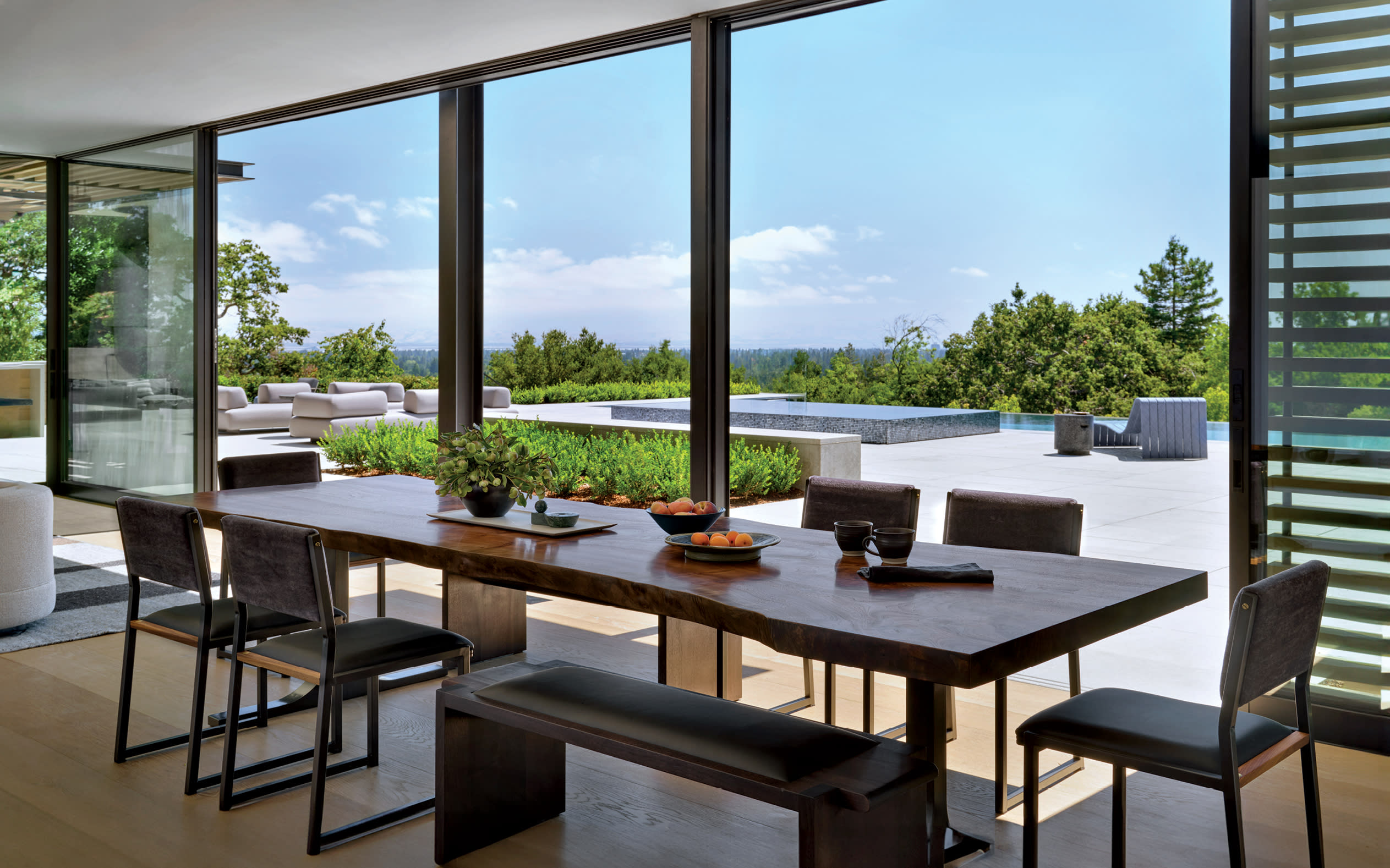 informal dining area with chairs and benches that look out to terraced deck 